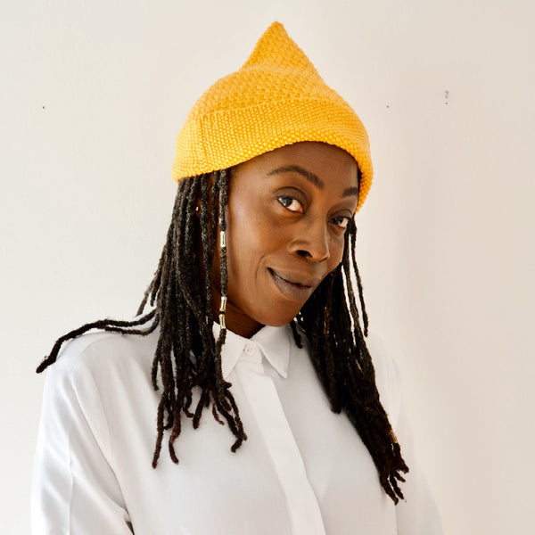 Model wearing hand knitted gold coloured woolen hat